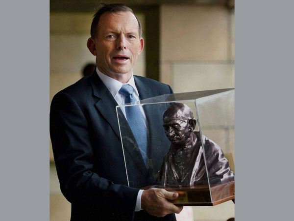 Australian Prime Minister Tony Abbott holding a bust of Mahatma Gandhi