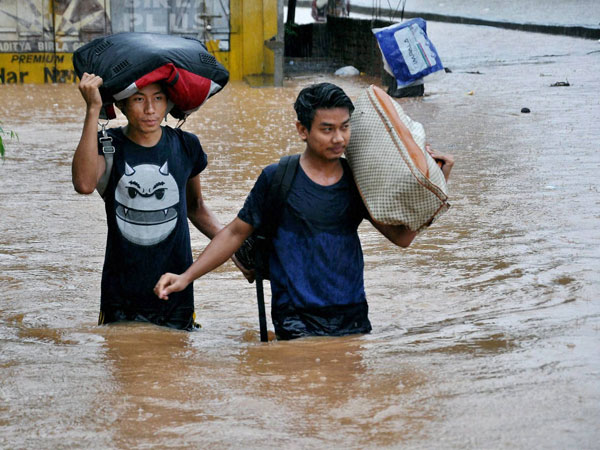 People wades through water logged street