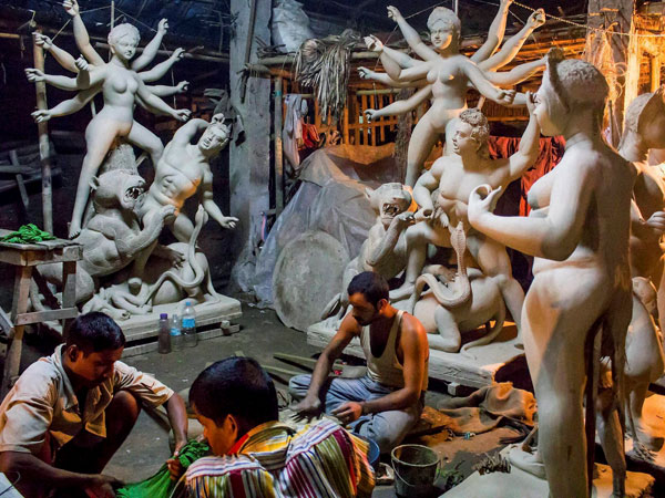 Artisans work on clay idols of Goddess Durga