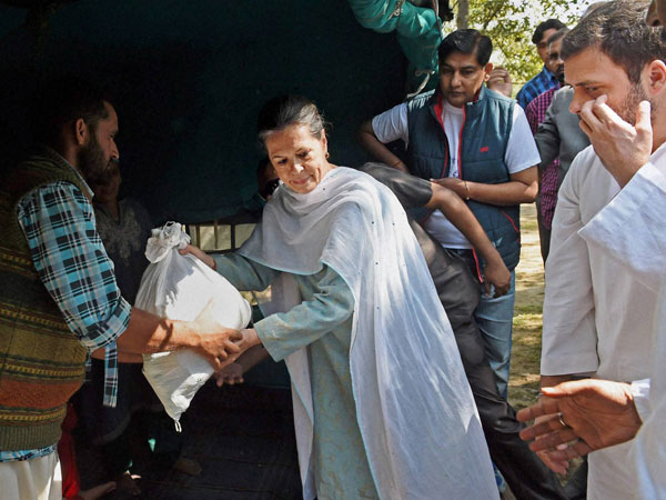 Sonia Gandhi along with her son Rahul Gandhi distributes relief material to the flood victims