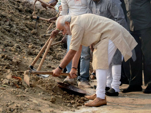 Varanasi: Prime Minister Narendra Modi wields a spade as he participates in the 'Swachh Bharat Campaign' at Assi Ghat in Varanasi on Saturday. (PTI Photo)