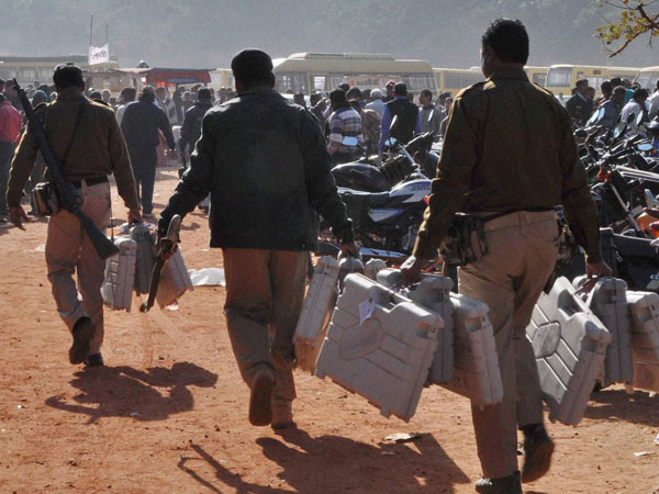 Police officials carry Electronic Voting Machines
