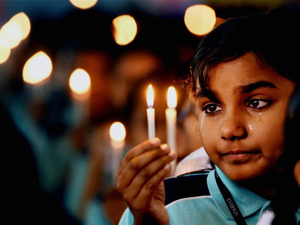 School Child prays during a candle light vigil