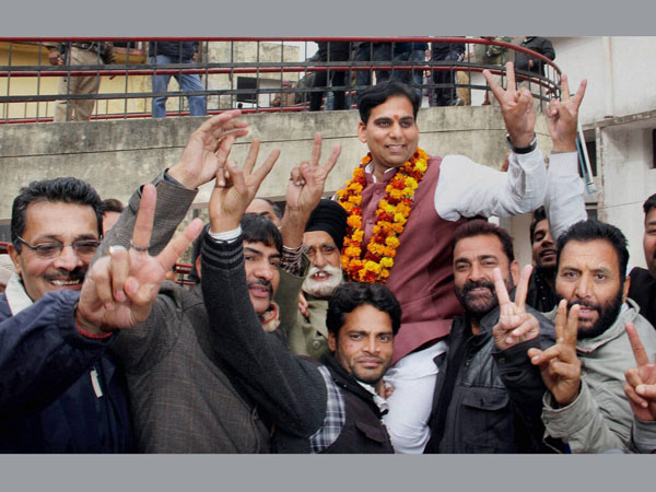 BJP candidate Gagan Bhagat with his supporters flash victory sign after won from R S Pura constituency in Jammu on Tuesday. BJP candidate Gagan Bhagat with his supporters flash victory sign after won from R S Pura constituency in Jammu on Tuesday.