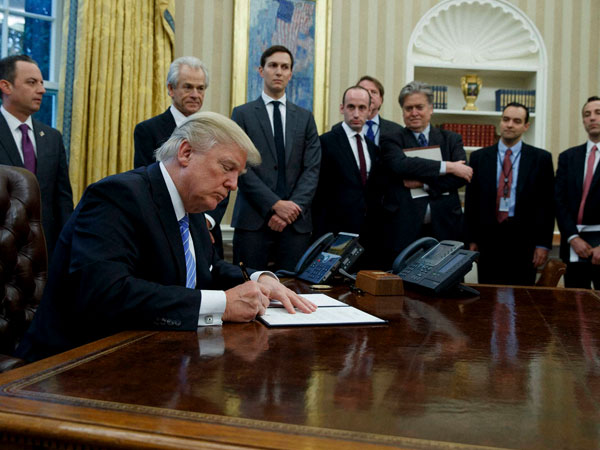 President Donald Trump signs an executive order in the Oval Office of the White House in Washington. President Donald Trump signs an executive order in the Oval Office of the White House in Washington.