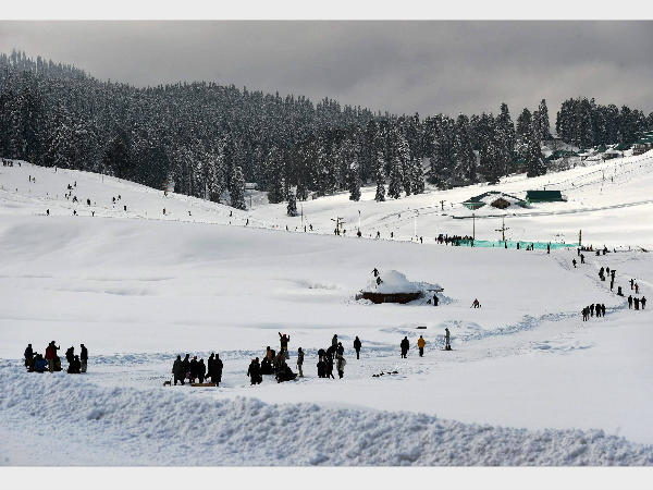 Tourists enjoy the snow in Gulmarg