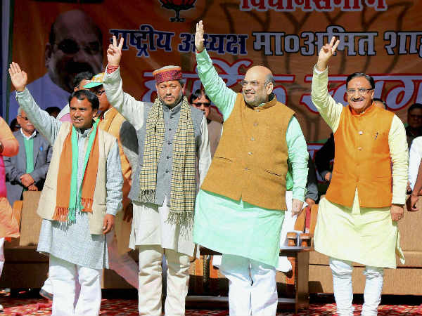 BJP National President Amit Shah with party leader Ramesh Pokhriyal and others waves at crowd at an election rally at Ramleela Ground in Pauri, Uttarakhand BJP National President Amit Shah with party leader Ramesh Pokhriyal and others waves at crowd at an election rally at Ramleela Ground in Pauri, Uttarakhand