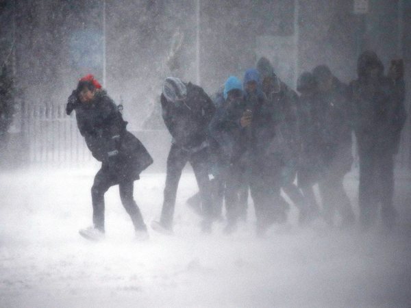 People struggling to walk in the winter storm