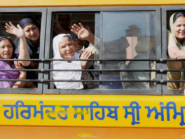 Sikh wave from a bus as they leave to board a special Pakistan-bound pilgrimage train to celebrate Baisakhi