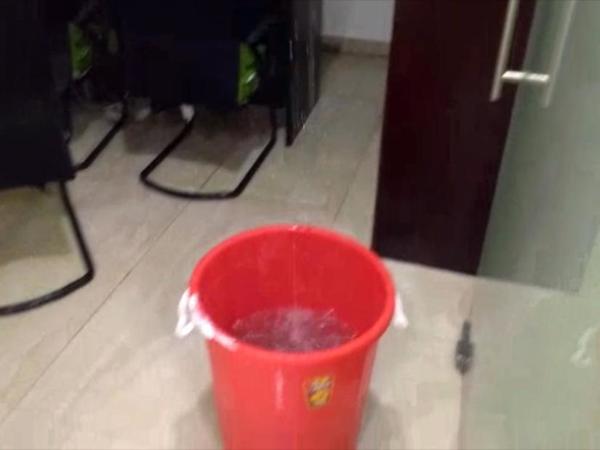 Office staff placed bucket under the leaking roof