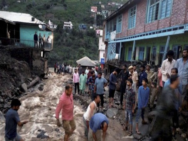 People walk across inundated road People walk across inundated road