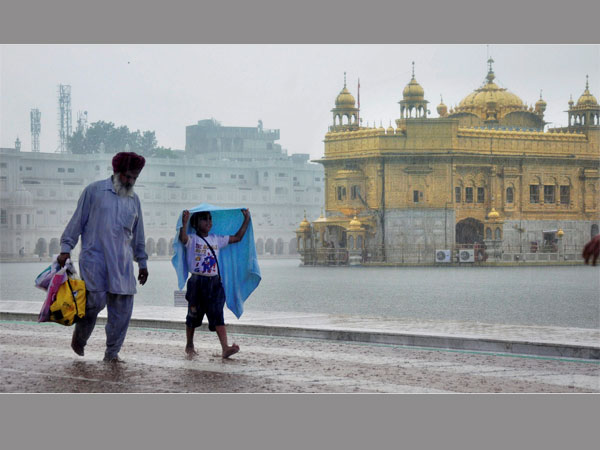 Devotess walking at Golden Temple during heavy rainfall in Amritsar. PTI file photo Devotess walking at Golden Temple during heavy rainfall in Amritsar. PTI file photo