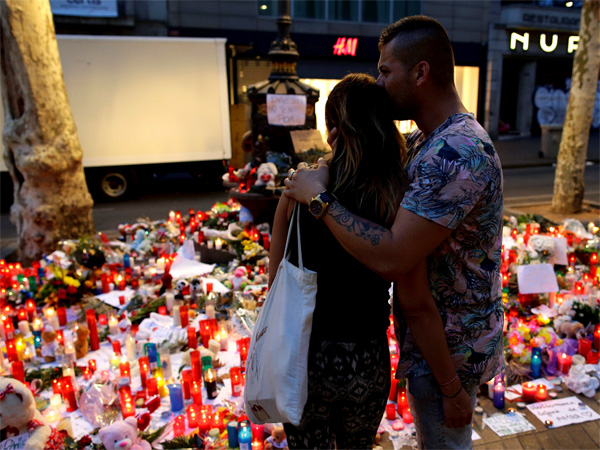 A couple looks at flags, messages and candles placed after van attack that killed at least 13, in central Barcelona, Spain, Saturday, Aug. 19, 2017. PTI file photo A couple looks at flags, messages and candles placed after van attack that killed at least 13, in central Barcelona, Spain, Saturday, Aug. 19, 2017. PTI file photo
