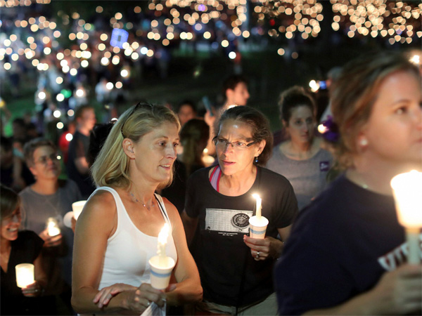 People participate in a candlelight vigil at the University of Virginia. Photo credit: PTI People participate in a candlelight vigil at the University of Virginia. Photo credit: PTI