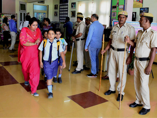 Parents take their children home after the murder of a class 2 student at Ryan International School as a police team looks on, in Gurugram Parents take their children home after the murder of a class 2 student at Ryan International School as a police team looks on, in Gurugram