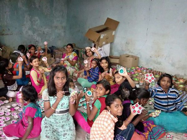 Children busy in making earthen lamps