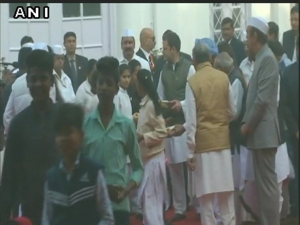 Rahul distributing sweets to children