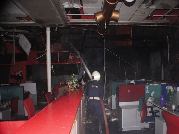 Firemen extinguish the fire and clear out debris