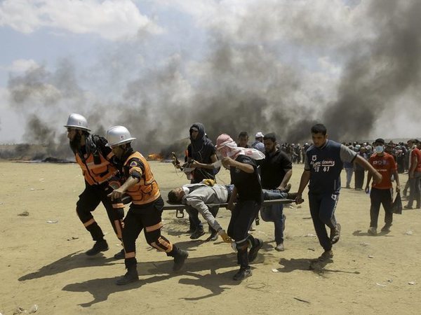 Palestinian medics and protesters evacuate a wounded youth during a protest at the Gaza Strips border with Israel, east of Khan Younis, Gaza Strip, Monday, May 14, 2018. Thousands of Palestinians are protesting near Gazas border with Israel, as Israel prepared for the festive inauguration of a new U.S. Embassy in contested Jerusalem. AP/PTI Palestinian medics and protesters evacuate a wounded youth during a protest at the Gaza Strips border with Israel, east of Khan Younis, Gaza Strip, Monday, May 14, 2018. Thousands of Palestinians are protesting near Gazas border with Israel, as Israel prepared for the festive inauguration of a new U.S. Embassy in contested Jerusalem. AP/PTI