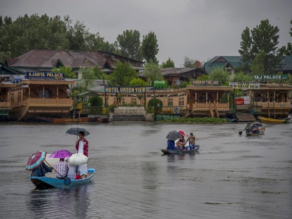People cross Dal Lake