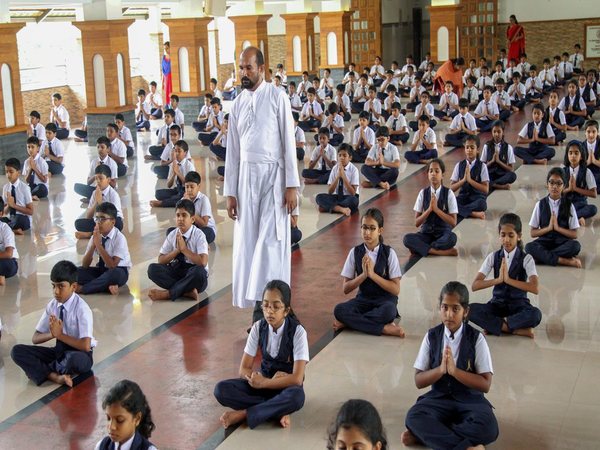 Students practice yoga on the eve of International Day of Yoga 2018 in Kozhikode