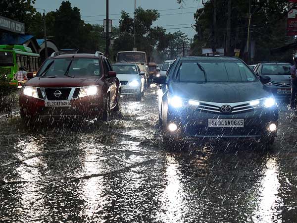 Vehicles ply at a road as it rains in New Delhi Vehicles ply at a road as it rains in New Delhi