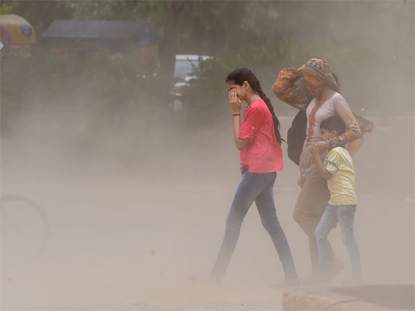 People walk through a dust storm, in New Delhi People walk through a dust storm, in New Delhi