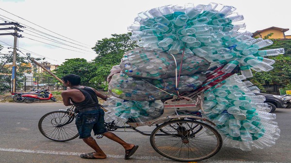 A rickshaw puller carrying empty plastic bottles to a recycling centre