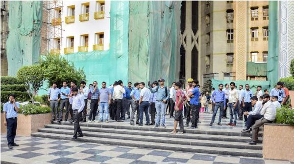 People come out of the Ambadeep Building at Connaught Place during a tremor in New Delhi