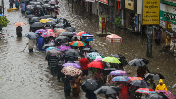 People wade through a flooded street during heavy rain, in Mumbai People wade through a flooded street during heavy rain, in Mumbai