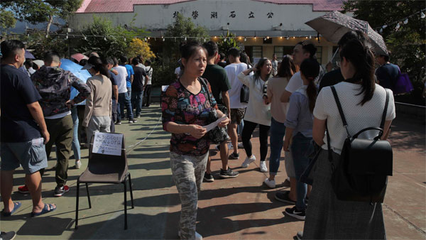 People line up to vote outside of a polling place in Hong Kong People line up to vote outside of a polling place in Hong Kong