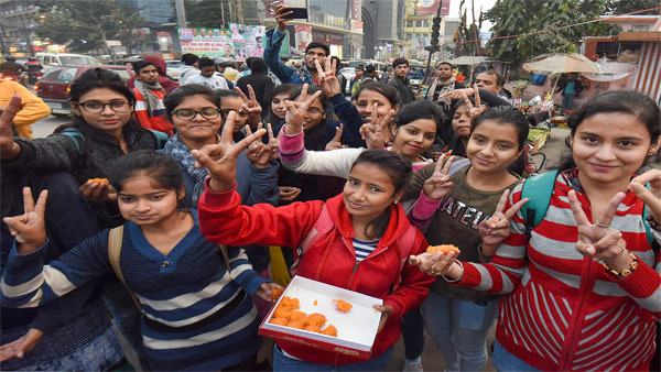 Young girls distribute sweets as they celebrate the Delhi court's verdict