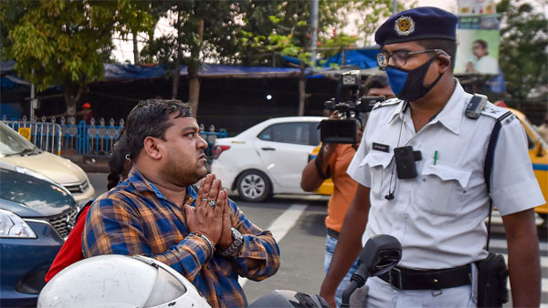 A biker apologizes after being stopped by a police personnel during lockdown in the wake of coronavirus pandemic, in Kolkata A biker apologizes after being stopped by a police personnel during lockdown in the wake of coronavirus pandemic, in Kolkata