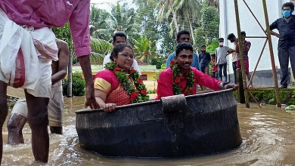 Kerala rains: bride, groom get married after reaching flooded hall in a cooking vessel Kerala rains: bride, groom get married after reaching flooded hall in a cooking vessel