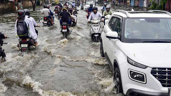 Vehicles wades through a waterlogged street after rains Vehicles wades through a waterlogged street after rains