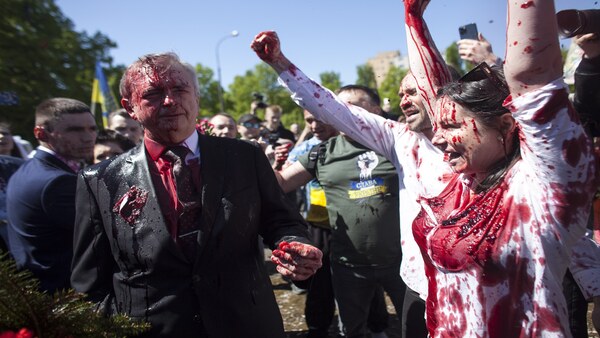 Activists shout slogans as Russian Ambassador to Poland, Ambassador Sergey Andreev, left, is covered with red paint in Warsaw, Poland. PTI Activists shout slogans as Russian Ambassador to Poland, Ambassador Sergey Andreev, left, is covered with red paint in Warsaw, Poland. PTI