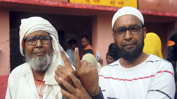 People show their inked fingers after casting votes at a polling station during by-poll People show their inked fingers after casting votes at a polling station during by-poll