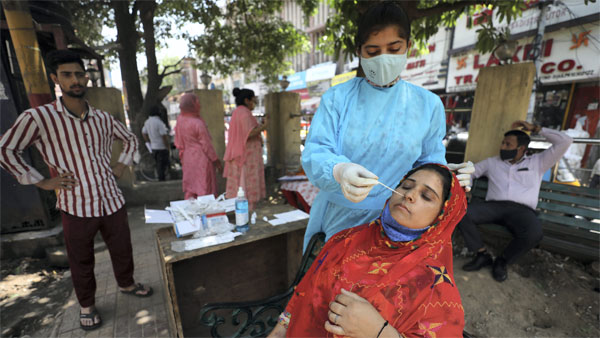 A healthcare worker collects a swab sample of a woman for Covid-19 testing A healthcare worker collects a swab sample of a woman for Covid-19 testing