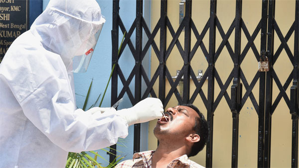 A medic takes sample from a patient showing cough and fever symptoms for COVID-19 test A medic takes sample from a patient showing cough and fever symptoms for COVID-19 test