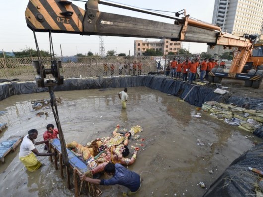 Devotees Immerse An Idol Of Goddess Durga Using A Crane At A Pond In Mayur Vihar, New Delhi